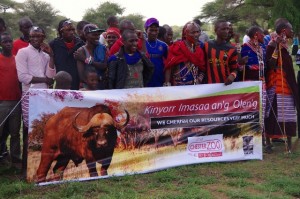 主催組織が会場に設置した幕と観客。幕にはマサイの言葉(マー語)と英語で、「わたしたちは、わたしたちの資源をとても大切に思っている」と書かれている。