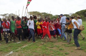 5000メートル走での優勝を祝って行進をする選手・関係者と、その様子を写真に撮ろうとする外国人やメディア関係者