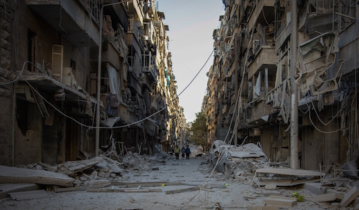 People walk down a street in Bustan Al Kasr neighbourhood after it was hit by airstrikes in mid-October 2016.© KARAM ALMASRI/MSF