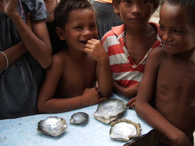 採集したクロチョウガイと真珠を前にしたサマ人の子供たち