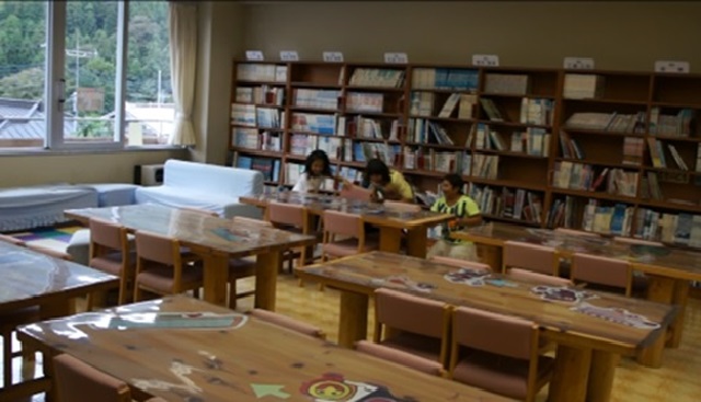 （写真3　休み時間の図書室：本棚の前に避難する子ども達（小学校C））