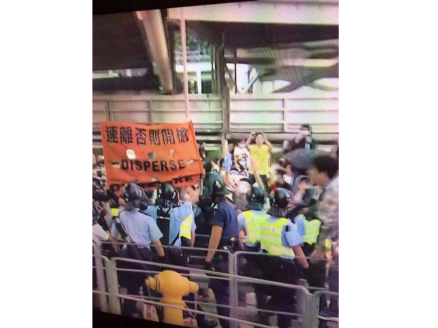 写真７：「すみやかに離れろ、さもないと撃つぞ」とデモ隊を脅す香港警察（14年9月28日）
