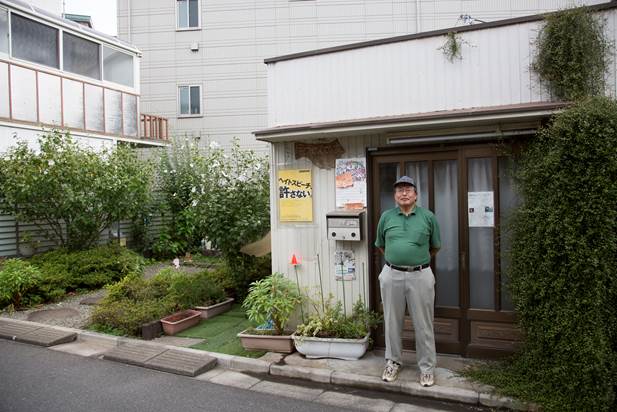 西崎雅夫氏（「ほうせんかの家」の前で）　写真撮影＝松井康一郎